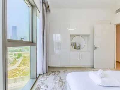 a bedroom with white walls and a large window at TRPS - Downtown Views II Tower 2, Downtown Dubai - 3BR plus Maids - Burj Khalifa View - Walk to Dubai Mall in Dubai