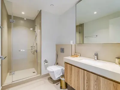 a bathroom with a shower and a toilet and a sink at TRPS - Downtown Views II Tower 2, Downtown Dubai - 3BR plus Maids - Burj Khalifa View - Walk to Dubai Mall in Dubai