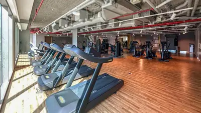 a gym with a row of treadmills at TRPS - Downtown Views II Tower 2, Downtown Dubai - 3BR plus Maids - Burj Khalifa View - Walk to Dubai Mall in Dubai