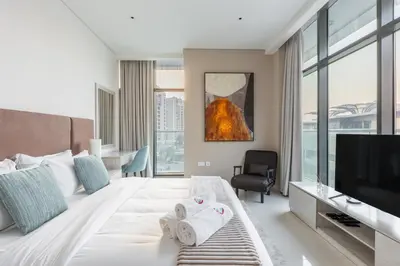 a hotel room with a bed and a television at Elegant Beachside Studio in Prime Palm Location in Dubai
