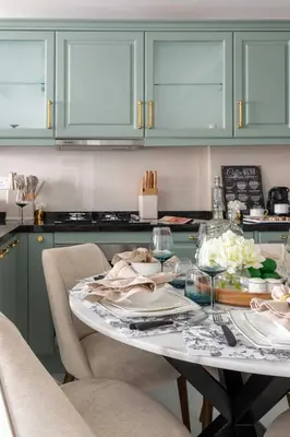 a kitchen with green cabinets and a table with wine glasses at Frank Porter - Vincitore Benessere 2 in Dubai
