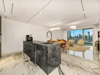 a living room with a table and a dining room at Elie Saab Collection by Luxe Manor - Dubai Mall Residences in Dubai