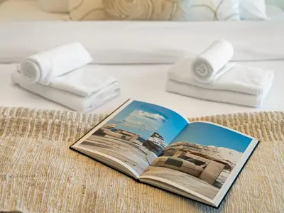a book on a bed with towels and towels at Elie Saab Collection by Luxe Manor - Dubai Mall Residences in Dubai
