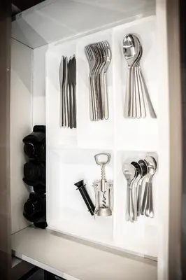 a white cabinet filled with utensils at Stylish 1-Bedroom Apartment with Modern Interior in Dubai