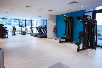 a gym with treadmills and elliptical machines at Stylish 1-Bedroom Apartment with Modern Interior in Dubai