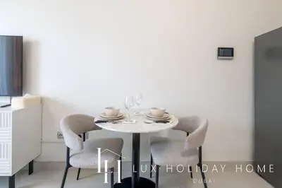 a dining room table with two chairs and a white table at LUX Dubai Hills Sway Studio in Dubai