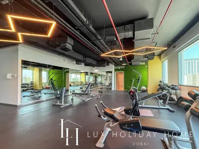 a gym with treadmills and ellipticals in a room at LUX Dubai Hills Sway Studio in Dubai