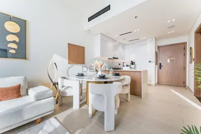 a kitchen and living room with a table and chairs at Newly Furnished Apartment near Circle Mall with Marina Views, Binghatti Onyx, JVC by Deluxe Holiday Homes in Dubai
