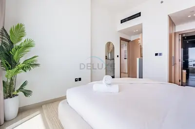 a white bedroom with a bed and a mirror at Newly Furnished Apartment near Circle Mall with Marina Views, Binghatti Onyx, JVC by Deluxe Holiday Homes in Dubai