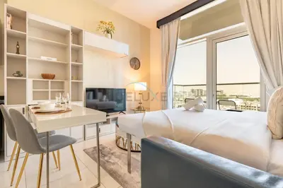 a bedroom with a bed and a table and a desk at Studio Near Dubai Butterfly Garden, 18 Mins Drive From Mall of Emirates, Miraclz Tower, Arjan By Deluxe Holiday Homes in Dubai