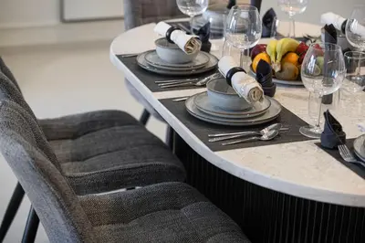 a table with plates and wine glasses on it at Sky-High Luxury 2BR Burj View Walk Dubai Mall in Dubai