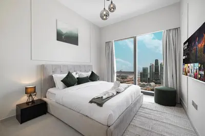 a white bedroom with a large bed and a large window at Sky-High Luxury 2BR Burj View Walk Dubai Mall in Dubai