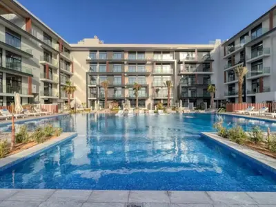 a large swimming pool in front of a building at Restay Homes - Chic Studio in JVC - Pool Views in Dubai