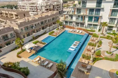 an aerial view of a swimming pool with apartment buildings at Restay Homes - Chic Studio in JVC - Pool Views in Dubai