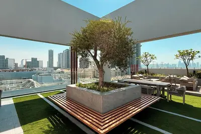 a patio with a tree on top of a building at Restay Homes - Chic Studio in JVC - Pool Views in Dubai