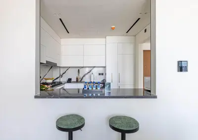 a mirror hanging above two stools in a kitchen at New 2BR with Jacuzzi and Big Balcony In City Center in Dubai