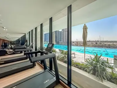 a gym with a view of a swimming pool at New 2BR with Jacuzzi and Big Balcony In City Center in Dubai