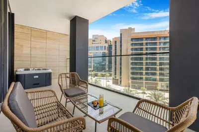 a balcony with chairs and a table and a large window at New 2BR with Private Jacuzzi in City Centre in Dubai