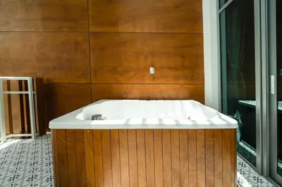 a bath tub in a bathroom with wooden walls at Luxury JVC 2 Bed Duplex with Private Pool and Jacuzzi in Dubai