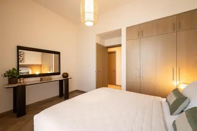 a bedroom with a white bed and a mirror at Seraya Residences at 52-42 EMAAR in Dubai