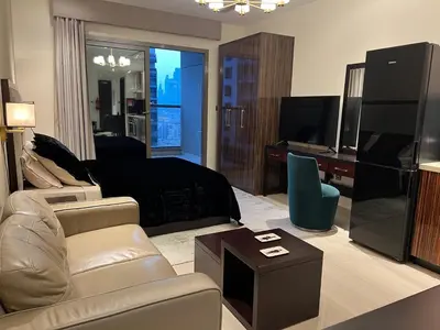 a living room with a bed and a tv and a couch at Luxury Downtown Studio - Elite Downtown Residence 1 - Burj Khalifa View Balcony in Dubai