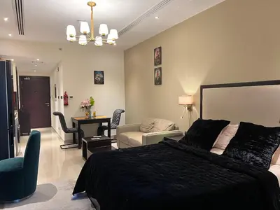 a bedroom with a black bed and a living room at Luxury Downtown Studio - Elite Downtown Residence 1 - Burj Khalifa View Balcony in Dubai