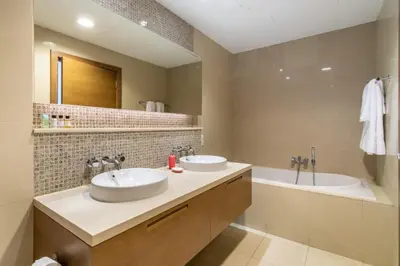 a bathroom with two sinks and a tub at Modern 2BR in the heart of Downtown Dubai in Dubai