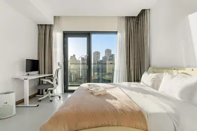 a bedroom with a bed and a desk and a window at Panoramic Marina 1BR City Skyline Views with Balcony, Pool & Gym Access in Dubai