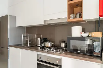a kitchen with a stove and a microwave at Panoramic Marina 1BR City Skyline Views with Balcony, Pool & Gym Access in Dubai