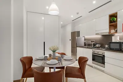 a dining room with a table and chairs in a kitchen at Panoramic Marina 1BR City Skyline Views with Balcony, Pool & Gym Access in Dubai
