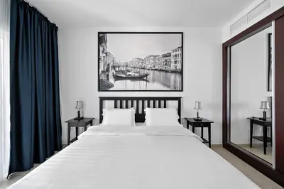 a bedroom with a large bed with a painting on the wall at High-Floor 1BR at Elite Residence, Dubai Marina in Dubai