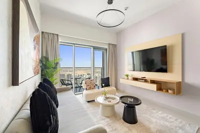 a living room with a couch and a tv at Elegant 1BR Near Burj Khalifa and Dubai Mall with Pool, Balcony, & Gym in Dubai