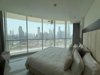 a bedroom with a bed with a view of a city at Full BurjKhalifa View - Luxury 2BR in 5Stars Hotel in Dubai