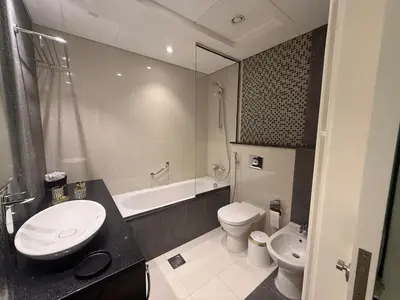 a bathroom with a sink and a toilet and a tub at Full BurjKhalifa View - Luxury 2BR in 5Stars Hotel in Dubai
