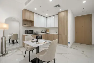 a kitchen with a table and chairs in a room at Stylish 1BR in Dubai Hills - Pool, Gym & Near Dubai Hills Mall in Dubai