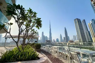 a view of a city skyline with tables and chairs at Spacious 2BR with Balcony, Stunning Burj Views & Steps from Bay Avenue Park in Dubai