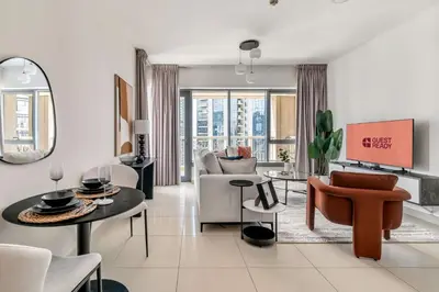 a living room with a couch and a table and chairs at GuestReady - Delightful haven near Burj Khalifa in Dubai