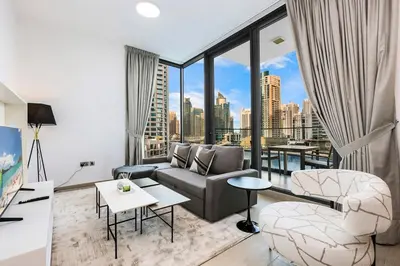 a living room with a couch and a large window at Stylish Dubai Marina 2BR with Balcony, Pool, Gym Walk to Marina Walk & JBR in Dubai