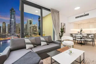 a living room with a couch and a view of a city at Stylish Dubai Marina 2BR with Balcony, Pool, Gym Walk to Marina Walk & JBR in Dubai