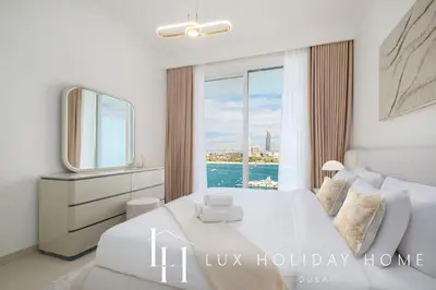 a bedroom with a white bed and a large window at LUX The Palace Beach Suite in Dubai