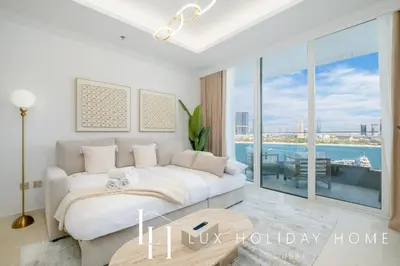 a white bedroom with a bed and a large window at LUX The Palace Beach Suite in Dubai