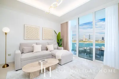 a living room with a couch and a table at LUX The Palace Beach Suite in Dubai