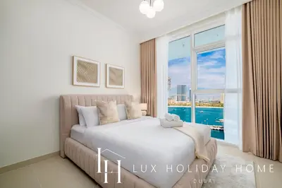 a bedroom with a bed and a large window at LUX The Palace Beach Suite in Dubai