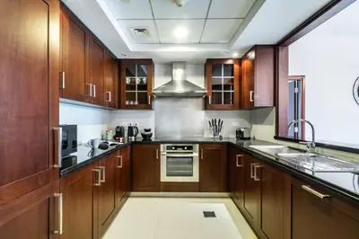 a large kitchen with wooden cabinets and a sink at 29 Boulevard Tower 1 Apartment by GLOBALSTAY in Dubai