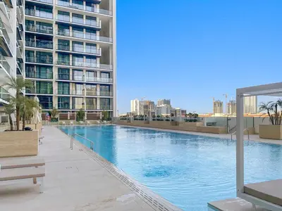 a large swimming pool in the middle of a building at Bright 1BR Retreat with Pool Access Near The Palm & Dubai Marina Hotspots in Dubai