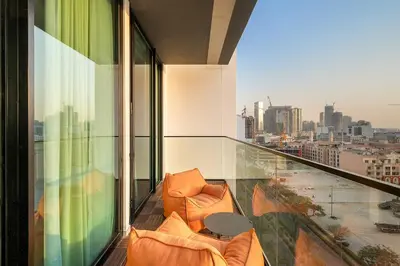 a balcony with two chairs and a table on a building at Bright 1BR Retreat with Pool Access Near The Palm & Dubai Marina Hotspots in Dubai