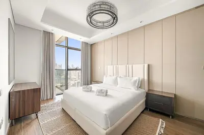a bedroom with a large white bed and a large window at Luxury 1BR apt with Burj Khalifa, Canal View Pool Gym Near Dubai Mall in Dubai