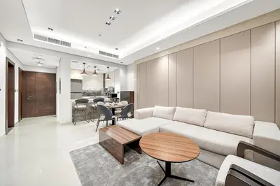 a living room with a white couch and a table at Luxury 1BR apt with Burj Khalifa, Canal View Pool Gym Near Dubai Mall in Dubai