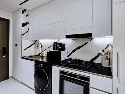 a kitchen with white cabinets and a stove and a microwave at Kazan Homes - Lux - Studio Close to Burj Khalifa & Dubai Mall - Business Bay in Dubai