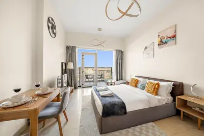 a bedroom with a bed and a table and a dining room at FIRST CLASS Studio Classy Comfort in Dubai